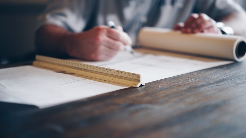 Person measuring and marking wood